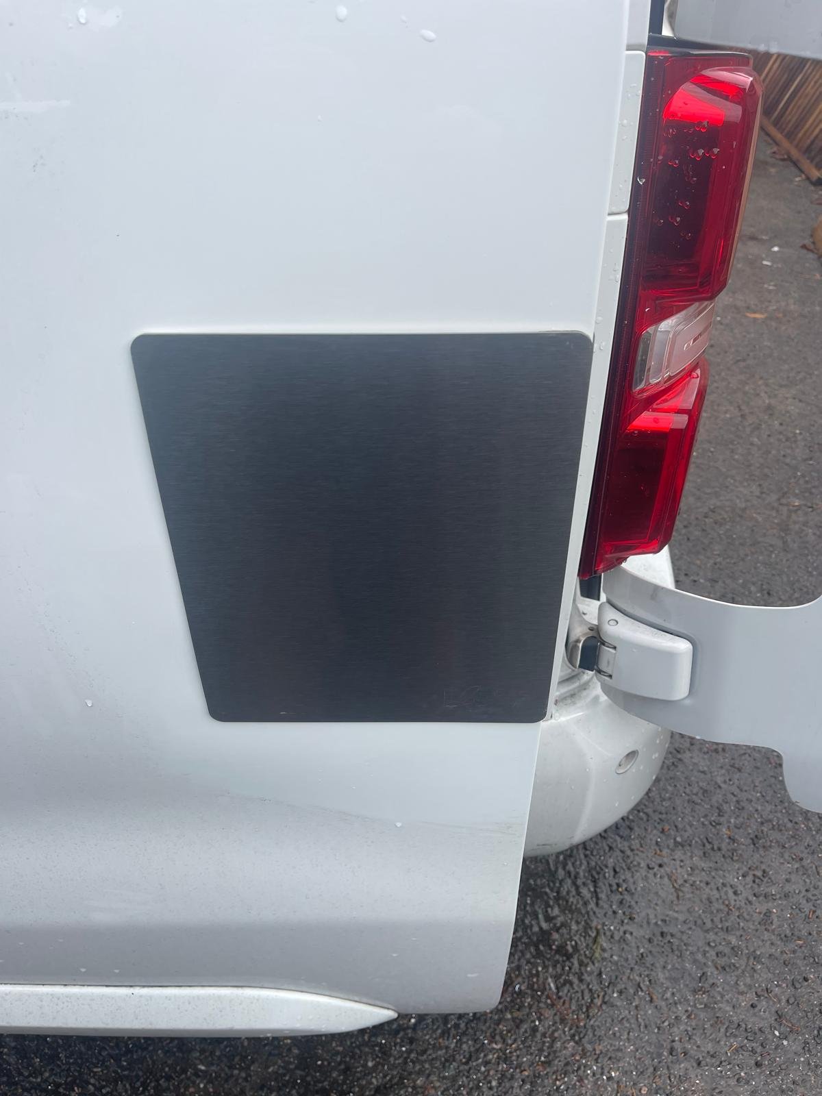 Van side panel repaired with a security plate covering the damage